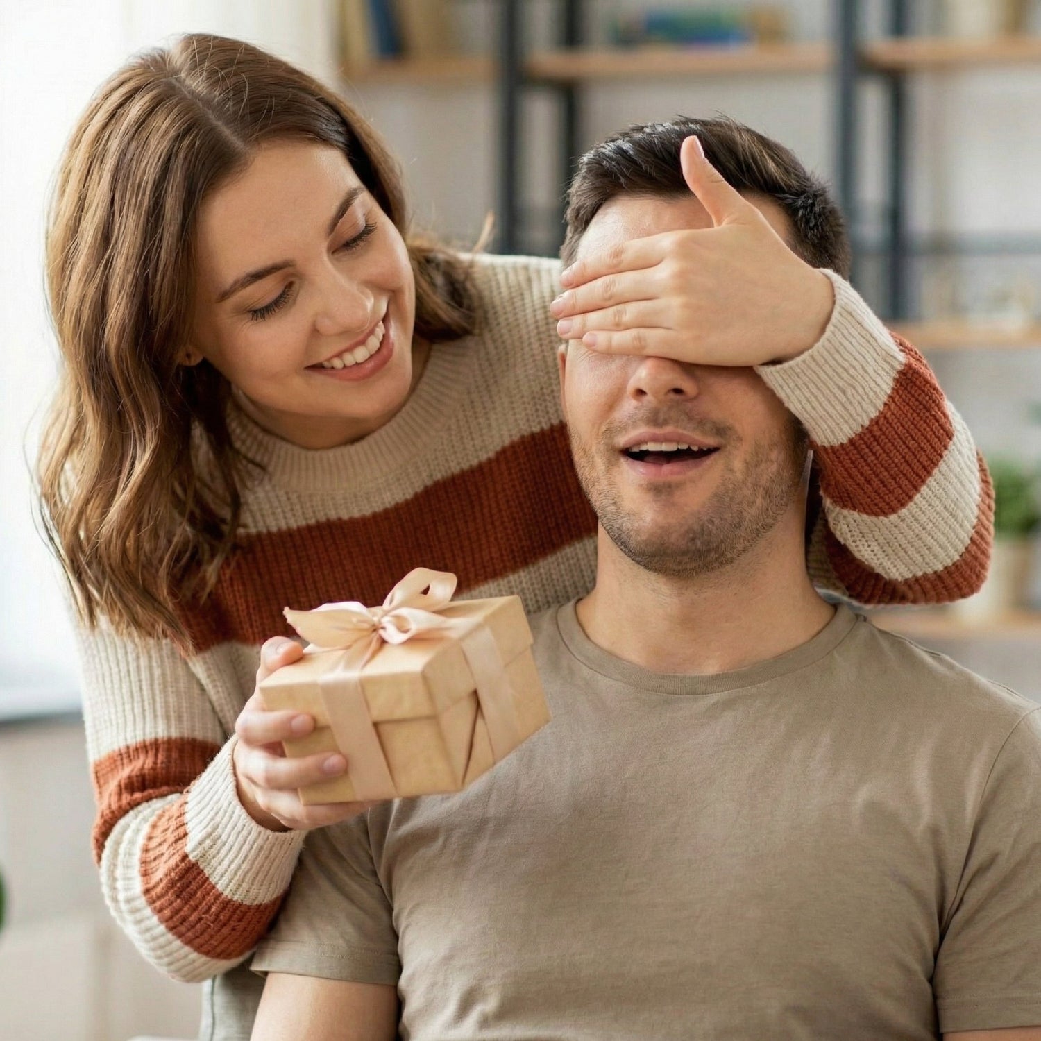 Cozy home surprise gift, woman covers man’s eyes while handing him a present